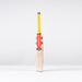 The Gray Nicolls Havoc HB317 GN330+ Junior Cricket Bat 2026 stands upright on a white surface with a yellow grip, orange branding, and checkered black-and-white label, showcasing its ultra-light pickup design against a light grey background.