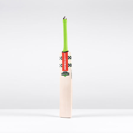 The Gray Nicolls Havoc 1.3 Test Lite Cricket Bat 2026 stands upright against a white background, featuring a bright green handle, red label, and checkered black-and-white design.