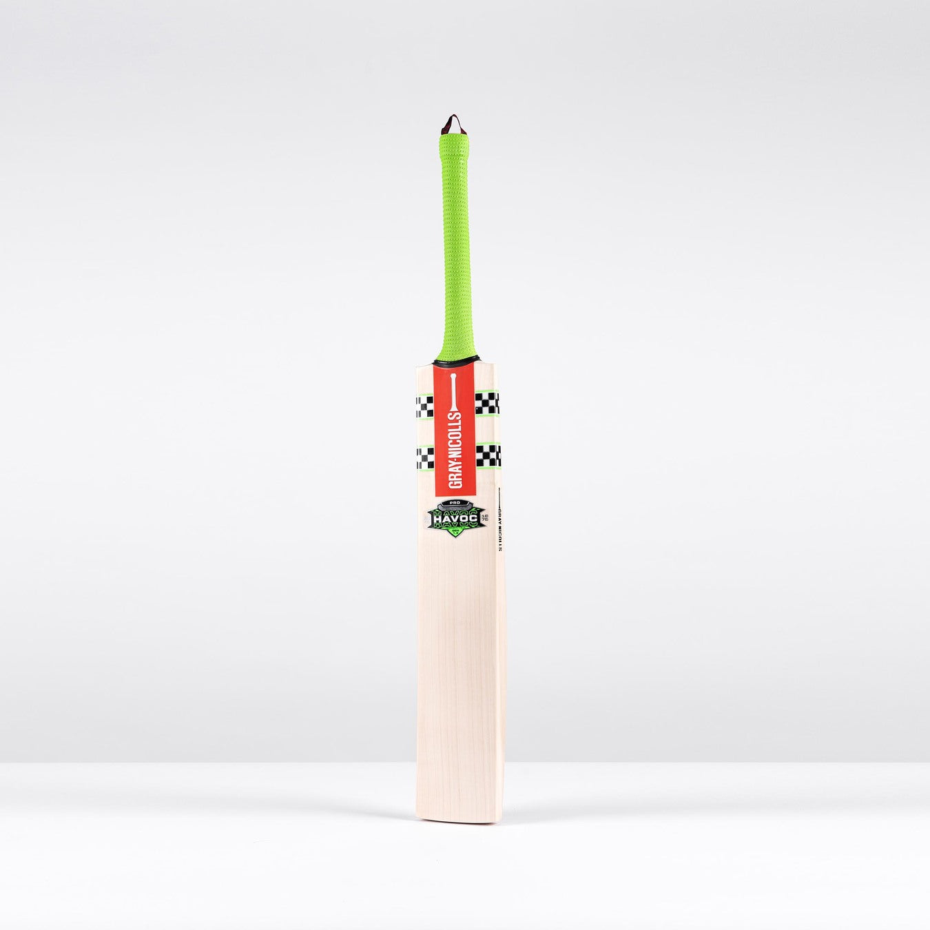 The Gray Nicolls Havoc 1.3 Test Lite Cricket Bat 2026 stands upright against a white background, featuring a bright green handle, red label, and checkered black-and-white design.