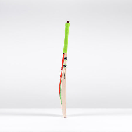 The Gray Nicolls Havoc 1.3 GN550 Junior Cricket Bat 2026, featuring a neon green grip and bold red and black decals, stands upright against a plain white background.