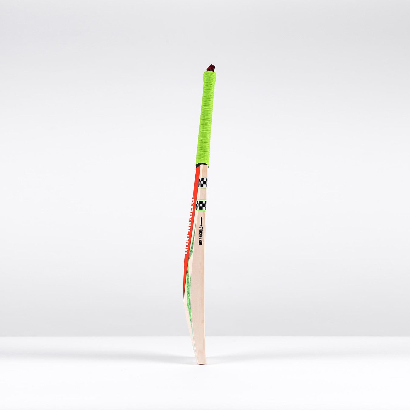 The Gray Nicolls Havoc 1.3 GN550 Junior Cricket Bat 2026, featuring a neon green grip and bold red and black decals, stands upright against a plain white background.