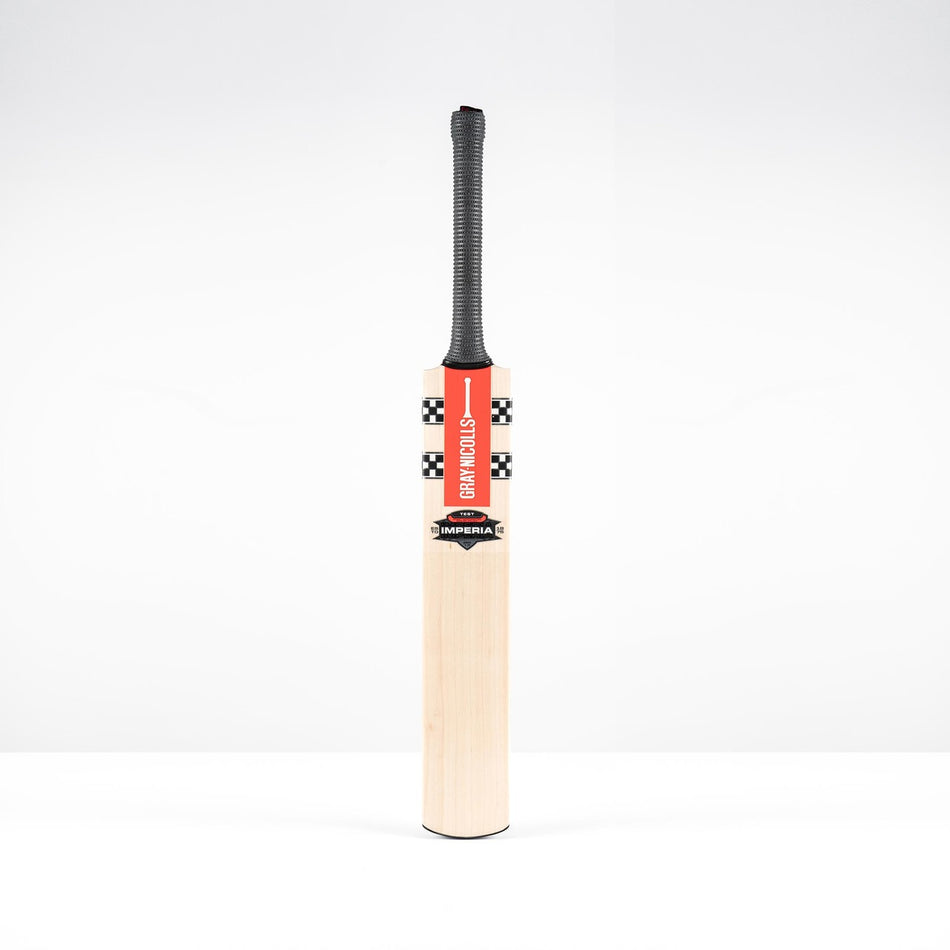 The Gray Nicolls Imperia 1.0 Test Cricket Bat 2026 features a black grip and red checkered label, standing upright against a plain white background.