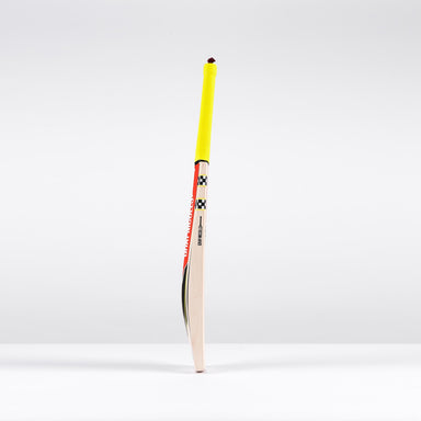 A Gray Nicolls Imperia 1.1 GN330+ Junior Cricket Bat 2026 with a yellow grip stands upright on a white surface against a plain, light gray background.