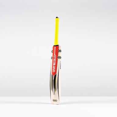 A Gray Nicolls Imperia 1.1 GN330+ Junior Cricket Bat 2026 with a yellow grip and bold red and black logo stands upright on a white surface against a light grey background—ideal for young players.