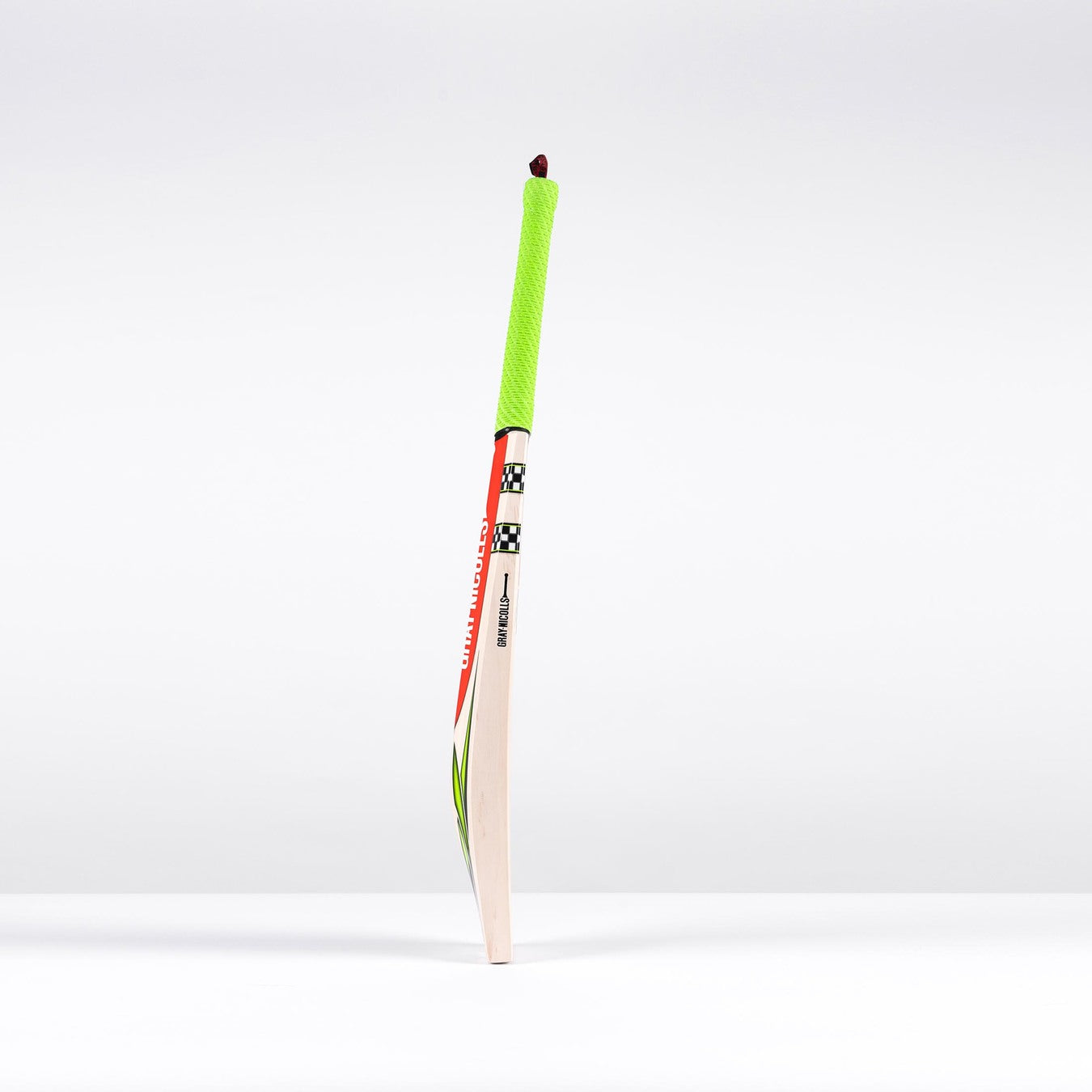 The Gray Nicolls Fusion Pro SH 2026 Cricket Bat features a bright green grip and stands upright on a white surface, highlighting its lightweight design and mid-to-low sweet spot against a plain background.