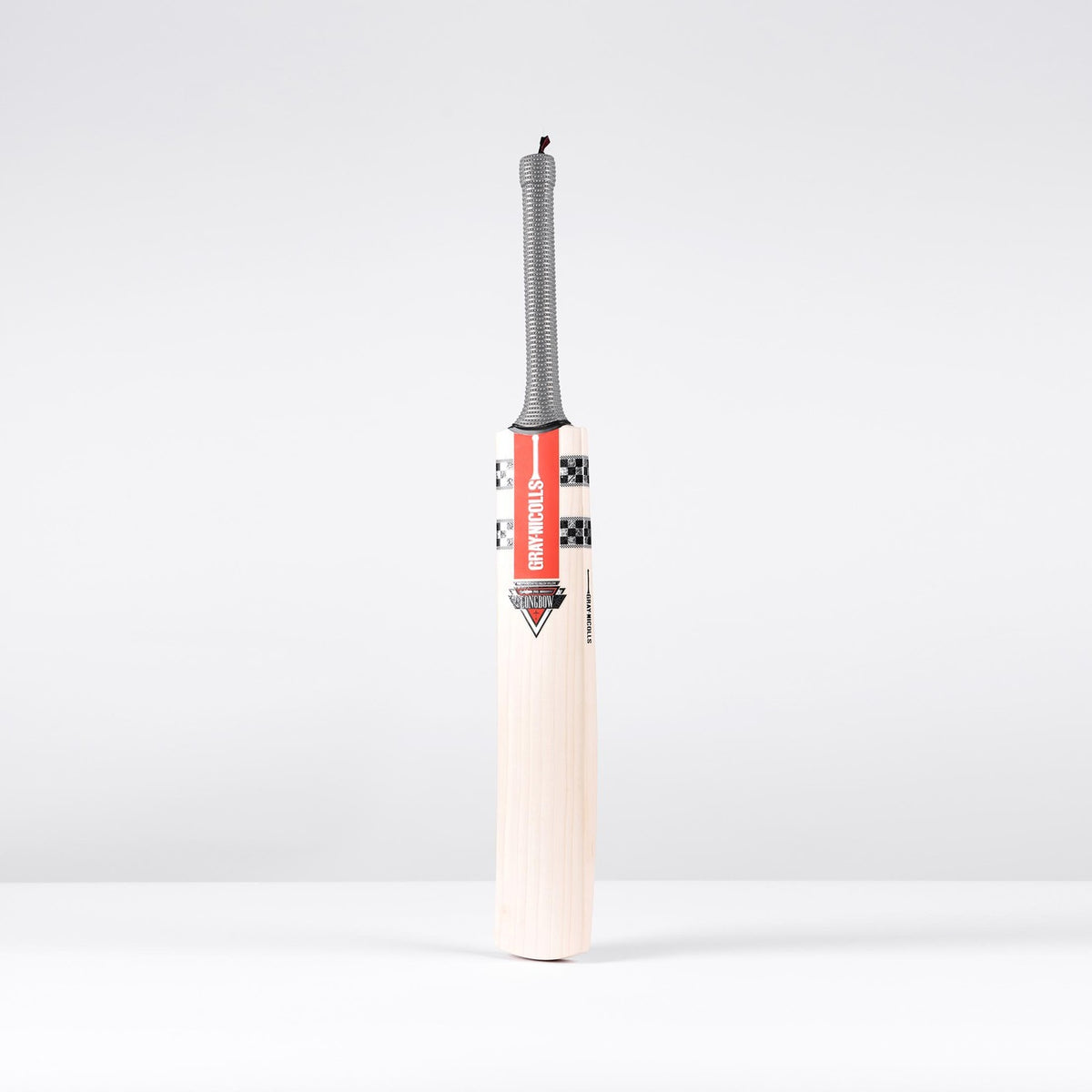 The Gray Nicolls Longbow Pro Junior Cricket Bat 2026, featuring a gray grip and mid-to-low sweet spot, stands upright on a white surface against a light gray background.