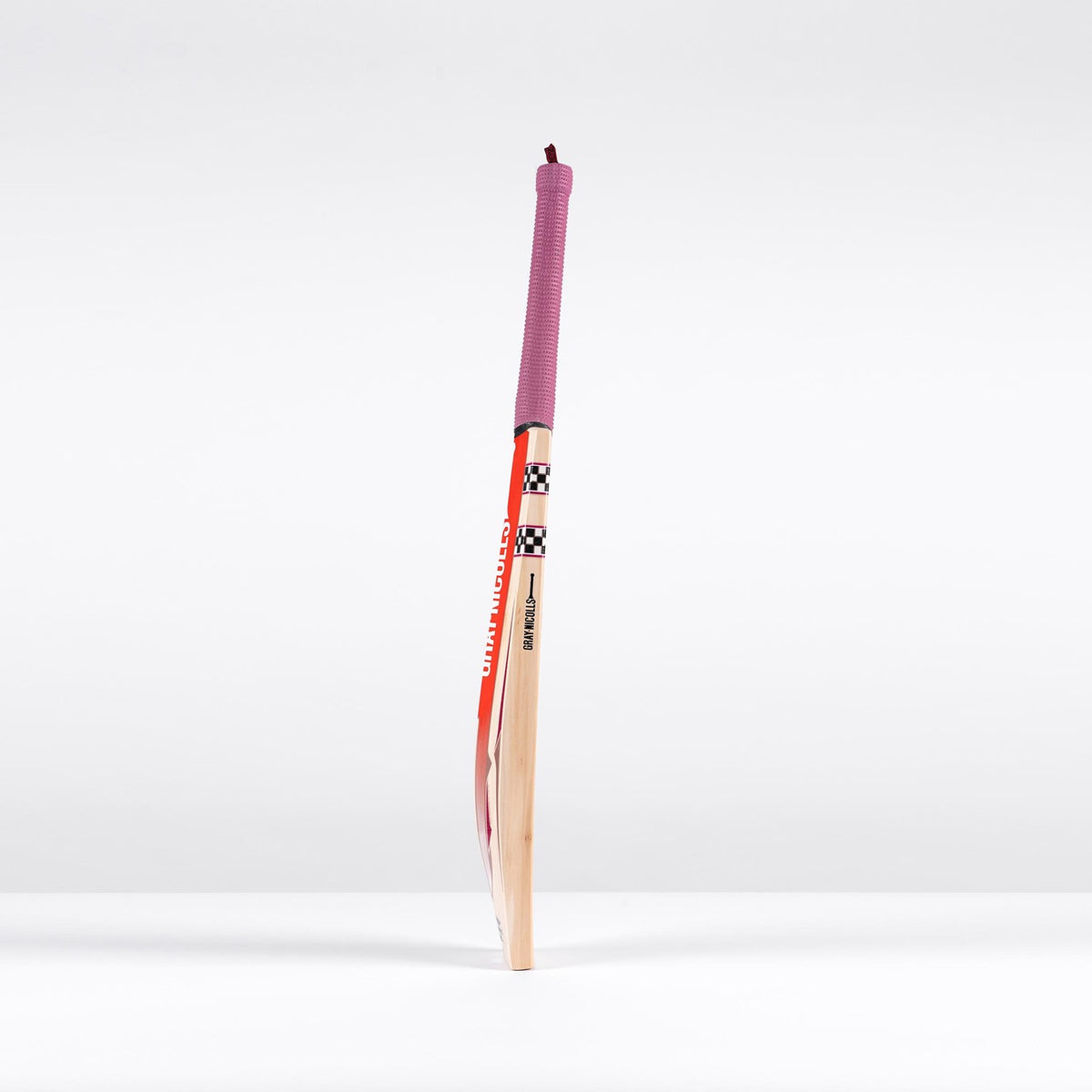 The Gray Nicolls GEM 3.1 Players Edition 2026 Cricket Bat, featuring a red handle grip and colorful design, stands upright against a plain white background, highlighting its lightweight build and elite performance.