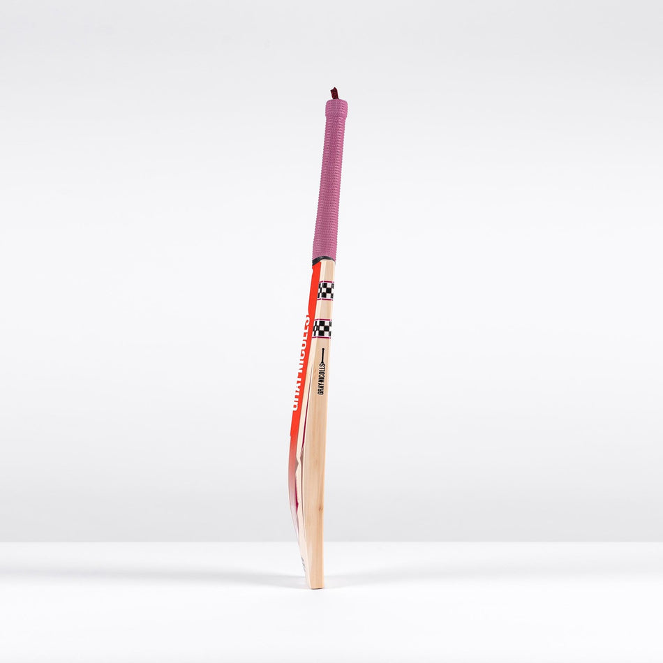 The Gray Nicolls GEM 3.1 Players Edition 2026 Cricket Bat, featuring a red handle grip and colorful design, stands upright against a plain white background, highlighting its lightweight build and elite performance.