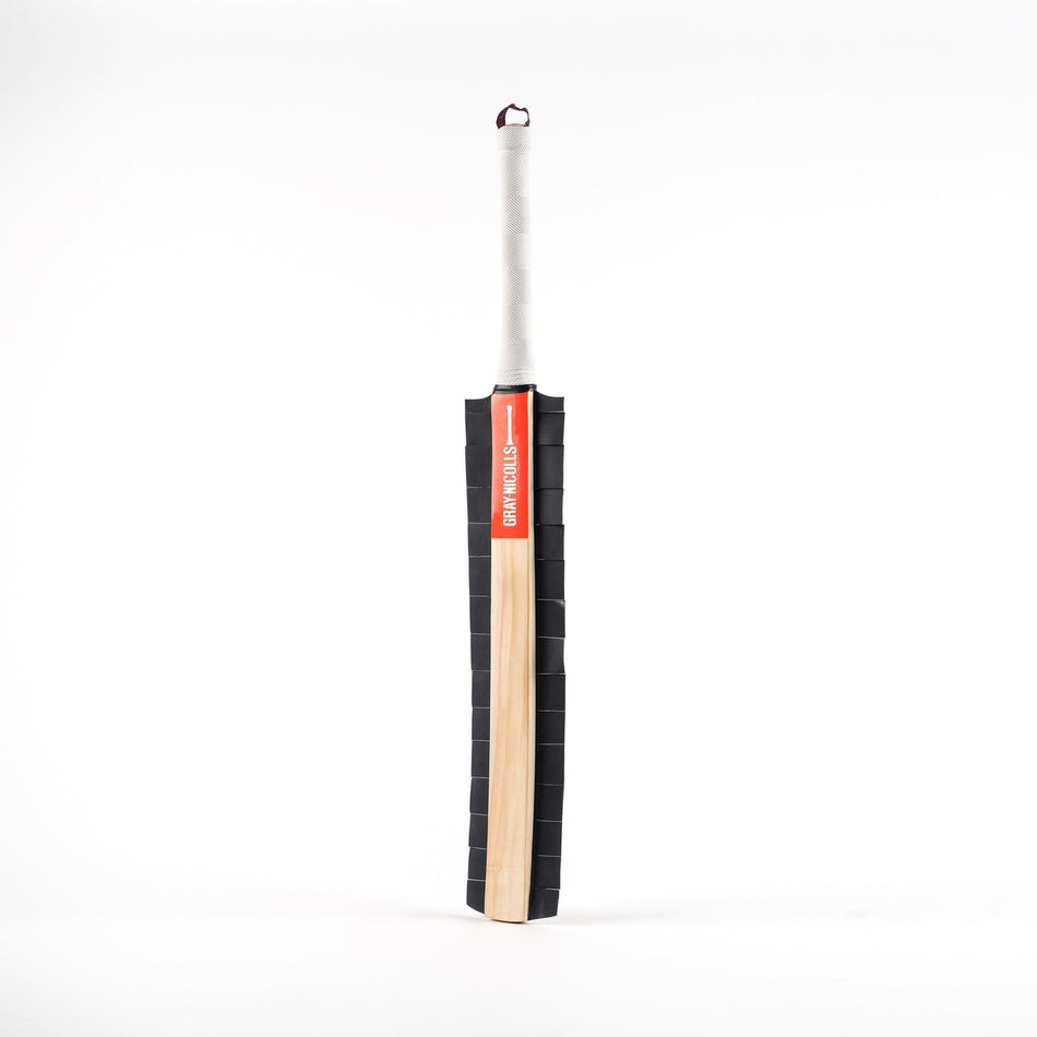 The Gray Nicolls Snicko Training Bat features a light English Willow blade, a white taped handle, and a black padded side cover—perfect for wicket keeper training—shown upright against a plain white background.
