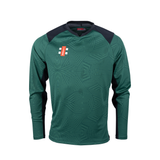 The Gray Nicolls Pro T20 Long Sleeve Match Shirt by Gray Nicolls features green/black colors, black shoulder panels, geometric patterns, and a red and white logo on the left chest, shown on a plain white background.