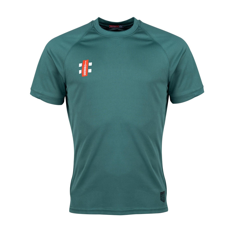 The Gray Nicolls Woodmancote CC Junior Matrix V2 T Shirt is a teal short-sleeve athletic top with moisture-wicking fabric, a small red rectangle logo, and white accents on the left chest, shown on a white background.