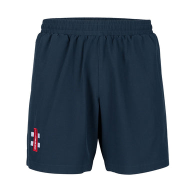 The Oldlands CC Velocity Training Shorts by Gray Nicolls are navy blue cricket training shorts featuring an elastic waistband and a small red and white logo patch near the left hem, with a plain design and no visible pockets.