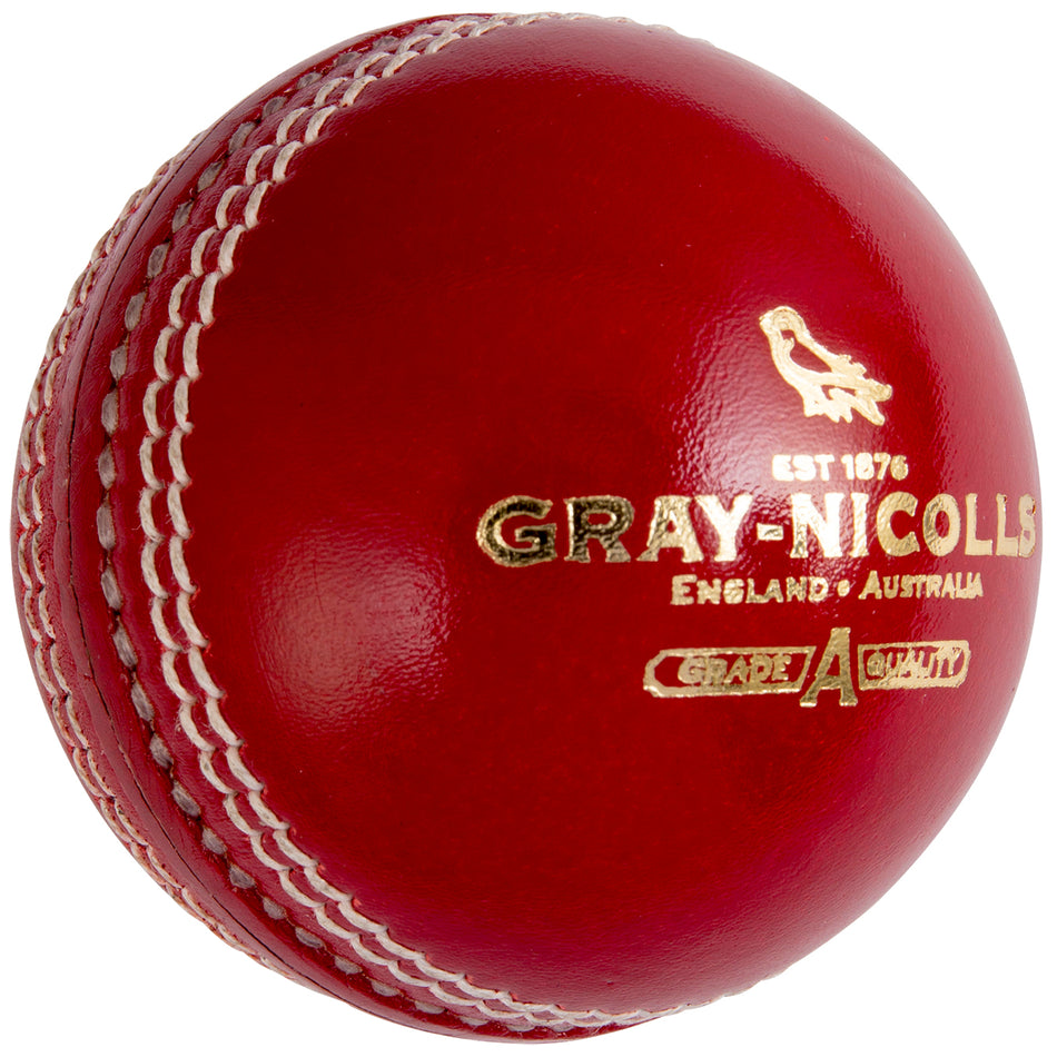 A close-up of the Gray Nicolls Crest Academy Cricket Ball, featuring shiny red leather, strong white machine stitching for durability, and gold Gray Nicolls branding.