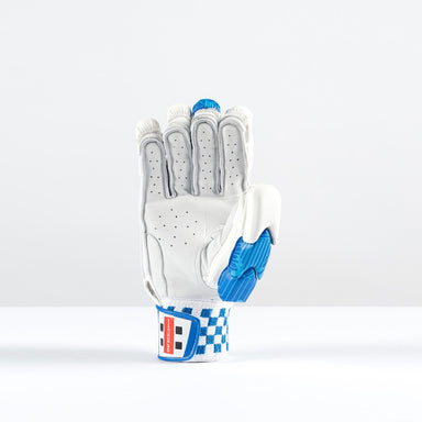 The Gray Nicolls Havoc 1.0 2000 Batting Gloves 2026, in white and blue premium leather with perforations, padding, and a geometric wrist strap design, is shown palm up on a white surface against a plain light background.