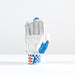 The Gray Nicolls Havoc 1.0 2000 Batting Gloves 2026, in white and blue premium leather with perforations, padding, and a geometric wrist strap design, is shown palm up on a white surface against a plain light background.