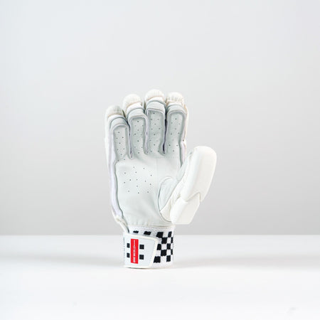 A single Gray Nicolls Classic Prestige Batting Glove 2026 stands upright on a white surface, palm forward. It features a durable leather palm, black ventilation holes, finger padding, and a red and black checkered wrist strap.