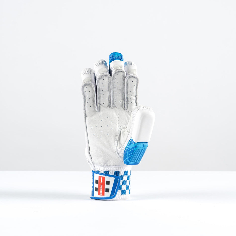 The Gray Nicolls Havoc 1.0 350 Batting Gloves 2026 feature a white and blue design, padded finger protection, checkered blue trim, and a red, white, and blue wrist strap. The glove stands upright on its wrist against a plain white background.