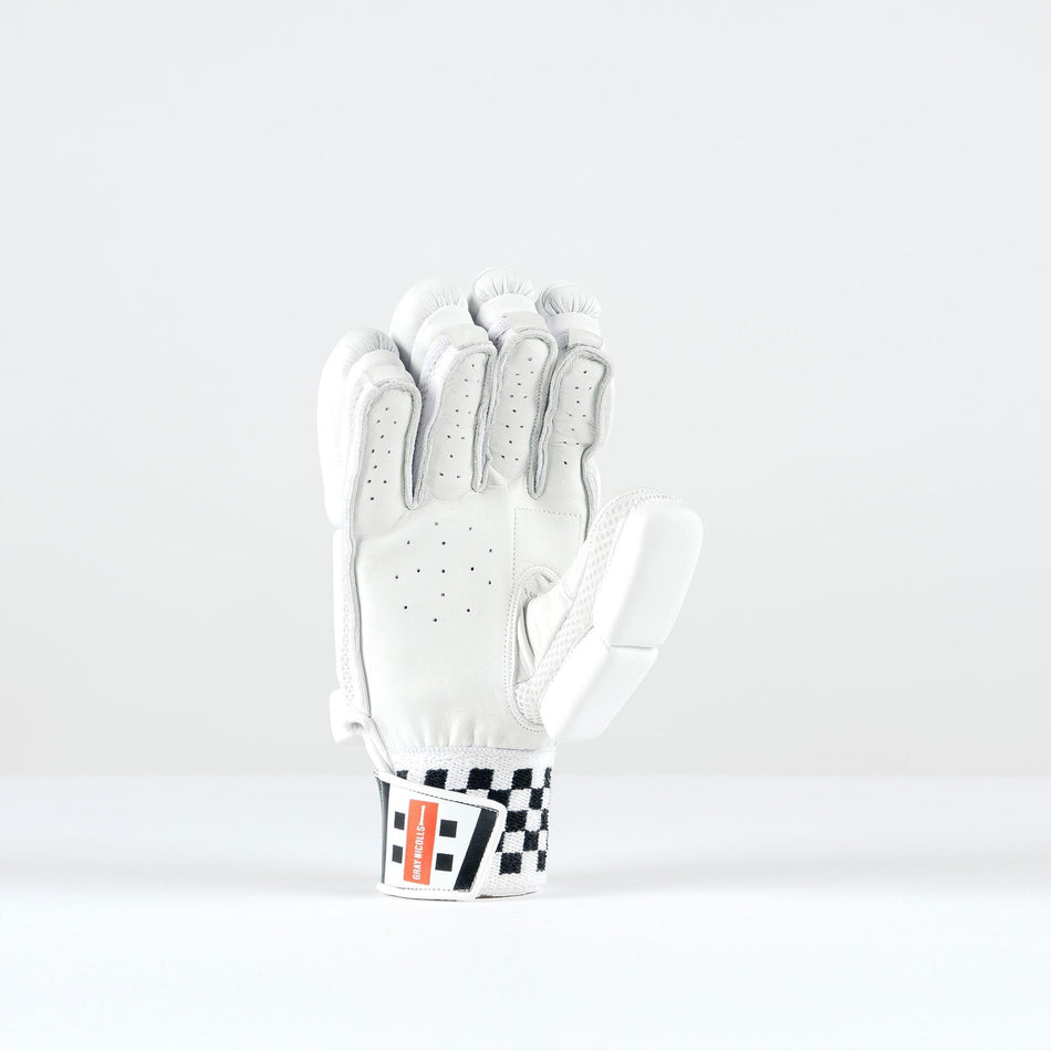 The Gray Nicolls Ultimate 500 Batting Glove 2026, in white with black checkered and red wrist strap details, stands upright on a plain background and features tri-layer protection for enhanced safety.