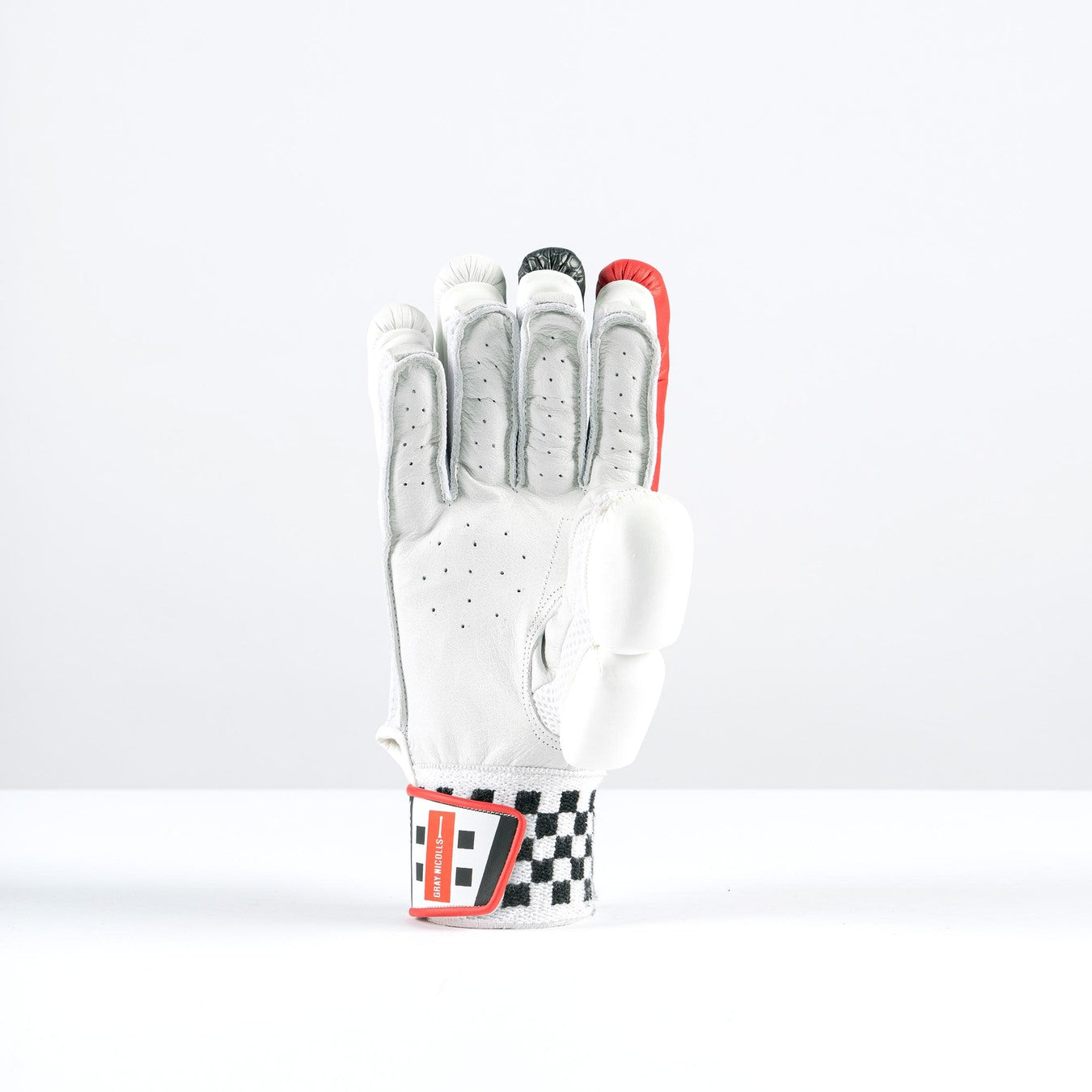 The Gray Nicolls Imperia 1.0 300 Batting Gloves 2026 stand upright on a white surface, palm forward, with black and red accents and the index finger raised in a number one gesture—a classic winner’s sign in club cricket.