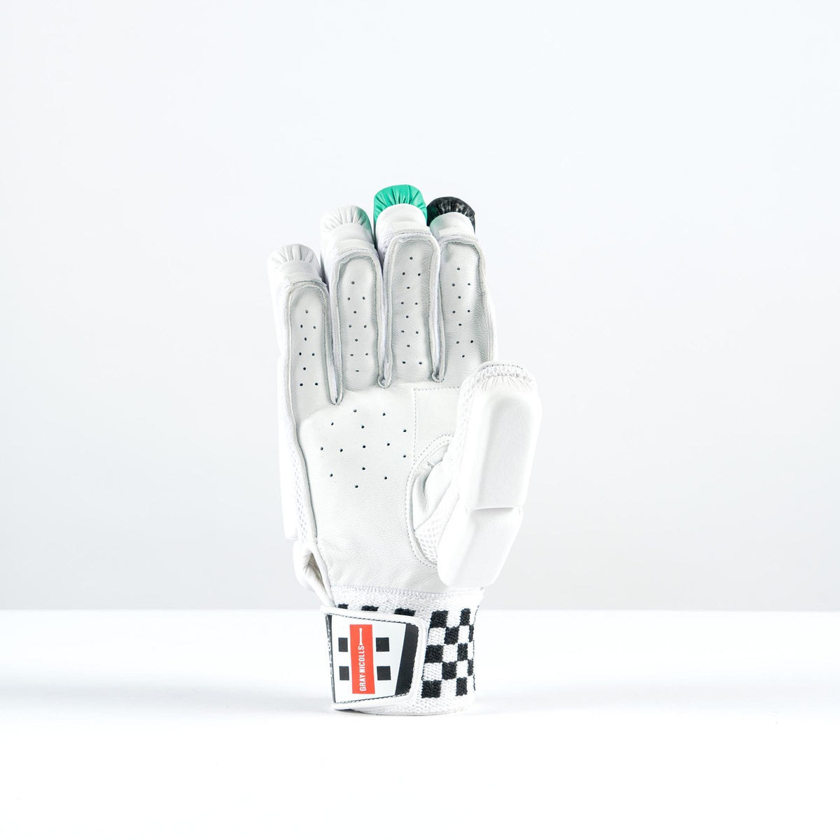 The Gray Nicolls GEM 3.1 400 Batting Gloves 2026, by Gray Nicolls, features high-density foam padding and a black-and-white checkered wristband. The glove stands upright, holding green poker chips against a plain white background.