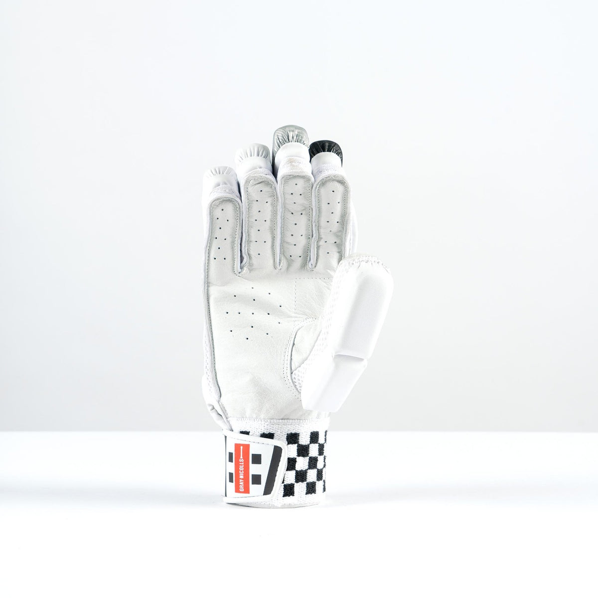 The Gray Nicolls GN400X Batting Glove 2026 features ventilation holes, a checkered black-and-white wrist strap, and red detailing, displayed upright on a white surface for superior grip and peak performance.