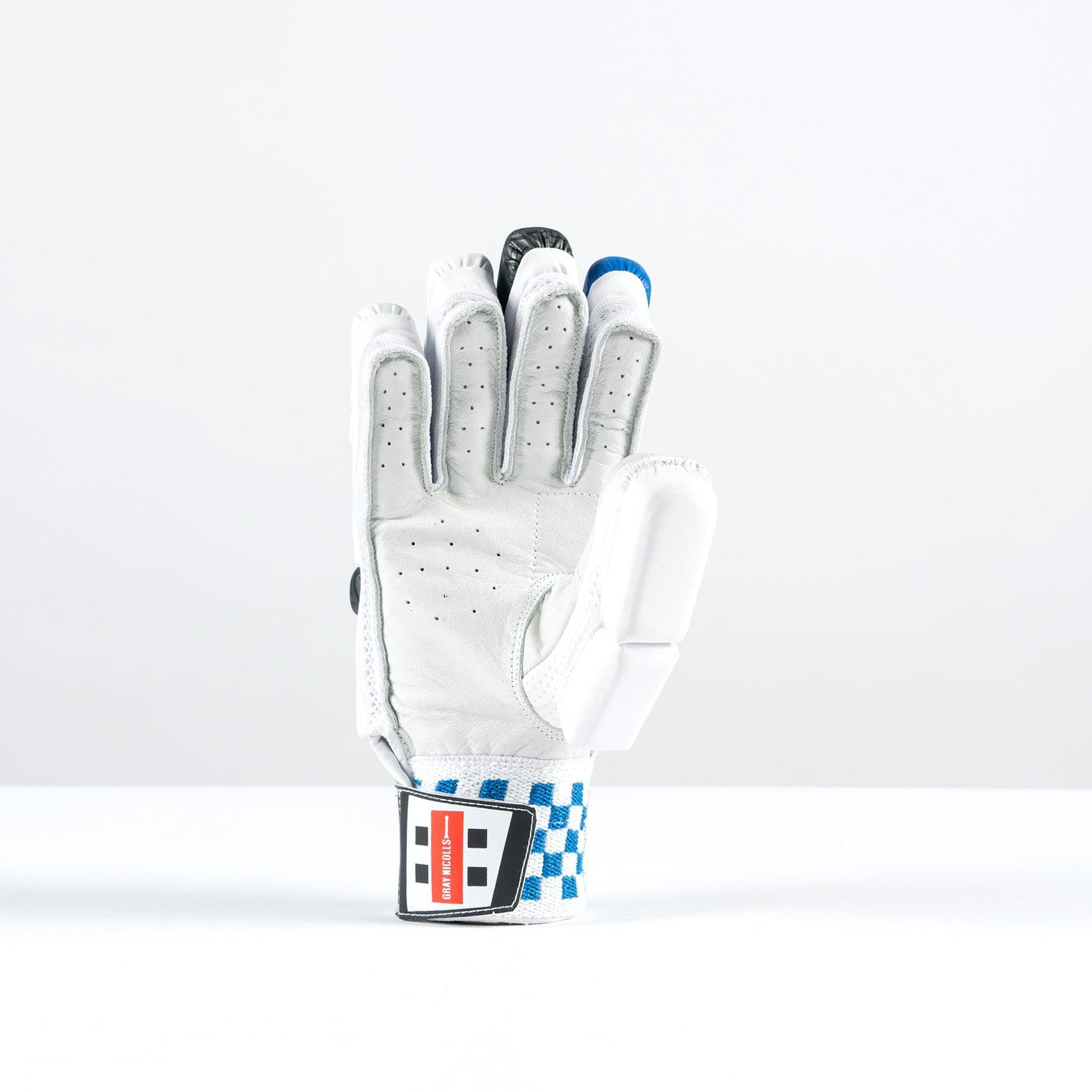 The Gray Nicolls GN200X Batting Gloves 2026, by Gray Nicolls, are white with black and blue accents, gray finger details, perforations for breathability, and a blue-and-white checkered strap with a red-and-black label near the wrist.