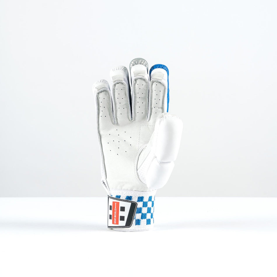 The Gray Nicolls GN100X Batting Gloves 2026, white with blue accents and a checkered wristband, is shown upright on a white surface with the palm facing forward against a plain background.