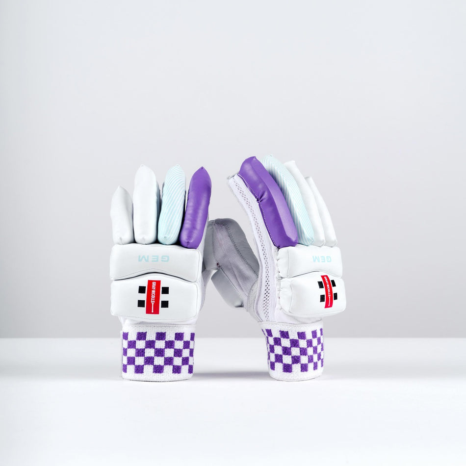 The Gray Nicolls GEM 2.1 Power Batting Gloves 2026 for women are white with purple and light blue accents, featuring a checkered purple-and-white wristband and black, red, and white logo patches on the wrist area.