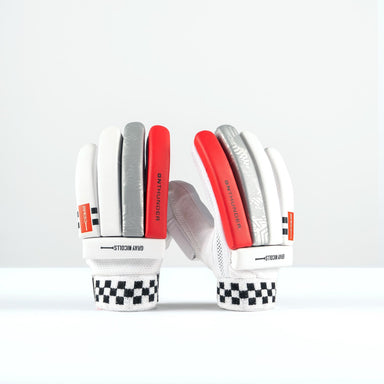 A pair of Gray Nicolls Thunder Batting Gloves 2026 in white, red, and silver stand upright on a white surface with palms facing away. The cuffs have a black and white checkered design, and “GK THUNDER” is printed on the sides.
