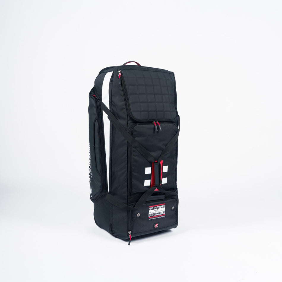 The Gray Nicolls Classic Pro Performance Wheelie 2026 cricket kit bag by Gray Nicolls features red zippers, white detailing, a quilted top section, carrying straps, a visible label near the base, and ample space for your gear.