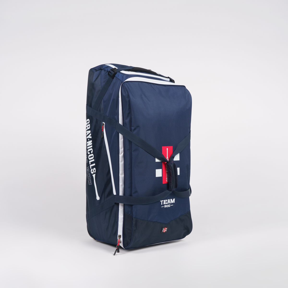 The Gray Nicolls Team 800 Wheelie—a large navy blue sports duffle with white zippers, red tag, and bold white branding—offers huge storage and a heavy-duty design. It stands upright on a plain white background.