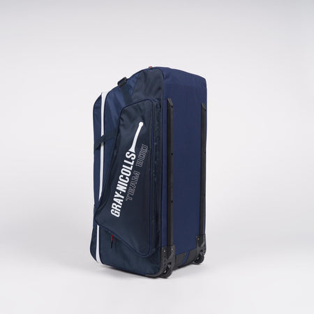A large navy blue Gray Nicolls Team 800 Wheelie heavy-duty bag with huge storage and a side pocket, featuring the text GRAY NICOLLS TEAM 800 and a white cricket bat graphic, stands upright against a plain white background.