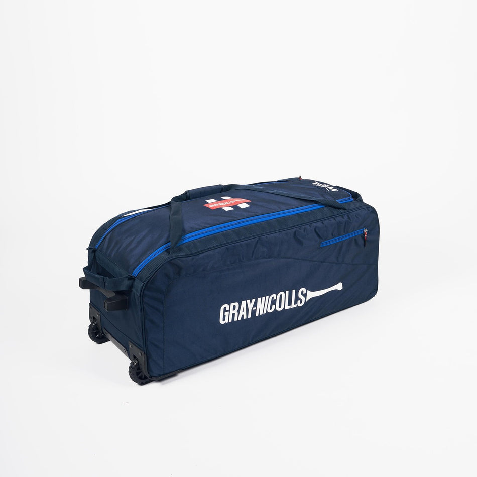 The Gray Nicolls Team 750 Wheelie 2026 is a large navy blue cricket kit bag with wheels and handles, featuring the GRAY NICOLLS logo and a white cricket bat graphic, shown on a plain white background.