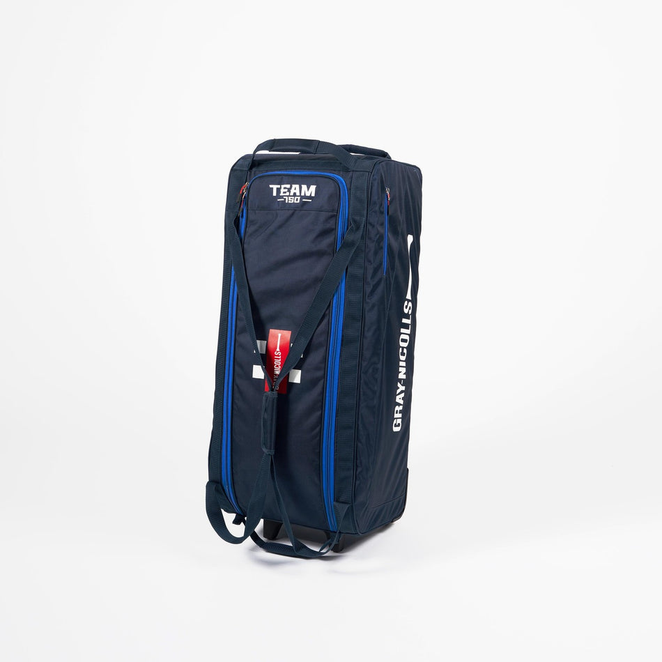 A large blue and black Gray Nicolls Team 750 Wheelie 2026 cricket kit bag stands upright on a white background, displaying visible carrying straps—a top matchday gear choice for any cricketer.