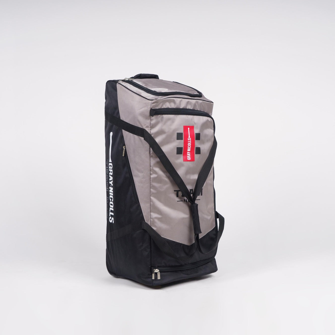 The Gray Nicolls Team 400 Wheelie is a large black/silver sports bag with deluxe wheels, black handles, and a red/white logo tag. The “Gray Nicolls” brand is visible on the side. It has a spacious main compartment and stands upright on a white background.