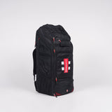 The Gray Nicolls Team 800 Duffle Bag 2026 is a large black sports duffle with red zipper accents, a white cross logo, padded double straps, a spacious shoe pocket, and the brand tag on the front pocket, shown against a plain white background.
