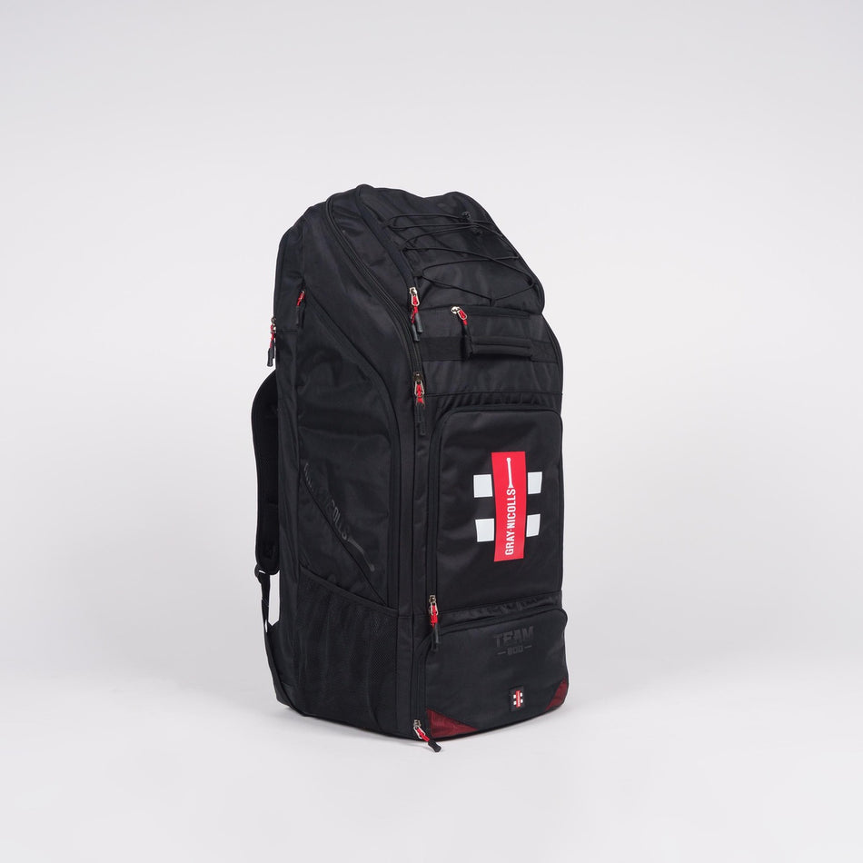 The Gray Nicolls Team 800 Duffle Bag 2026 is a large black sports duffle with red zipper accents, a white cross logo, padded double straps, a spacious shoe pocket, and the brand tag on the front pocket, shown against a plain white background.