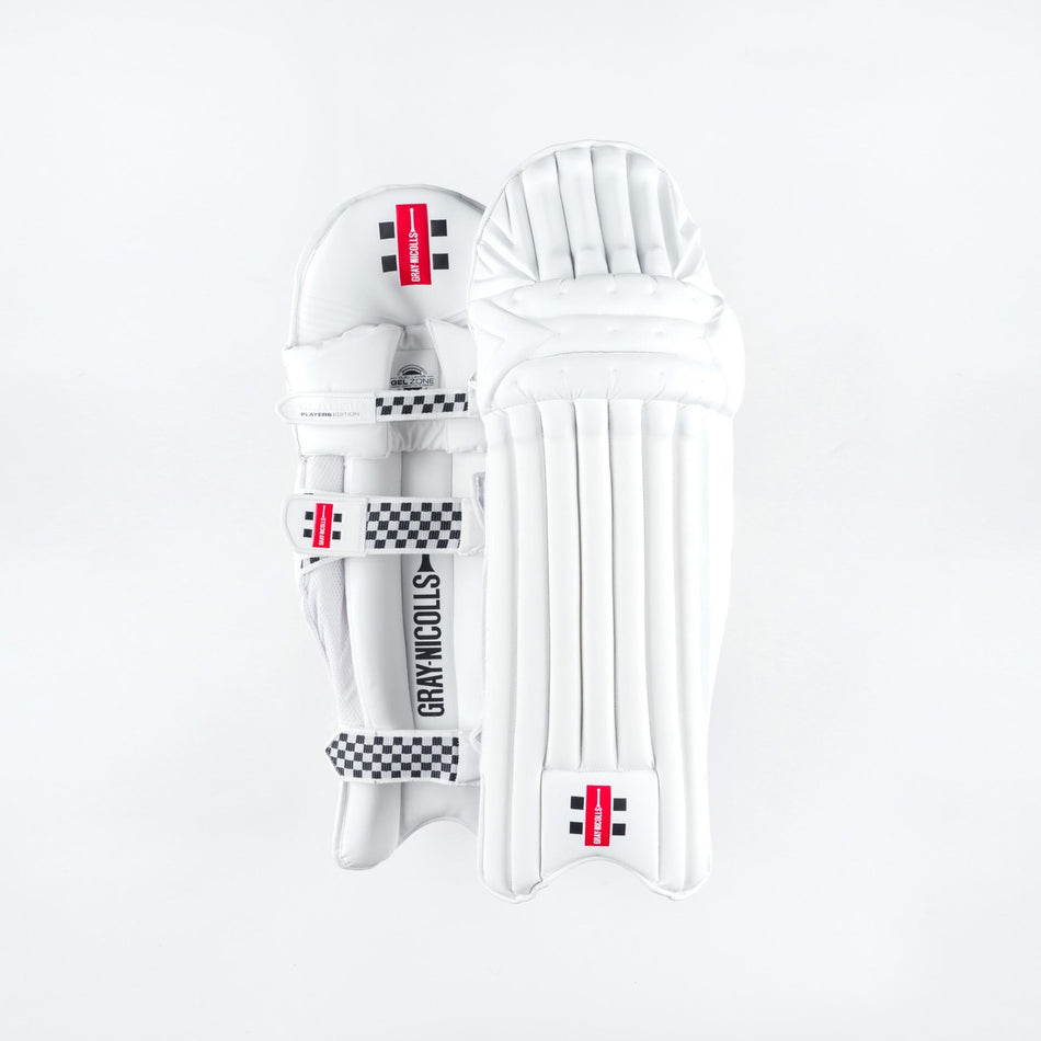 The Gray Nicolls Classic Players Edition Batting Pads 2026 are white leg guards with black and red branding, checkered straps, and lightweight HDF multi-layer protection, shown against a plain white background.