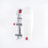 Two Gray Nicolls Classic Select Batting Pads 2026 in white are shown: one displays the front with vertical padding, while the other shows the back with straps and a checkered design, both featuring classic black and red branding.