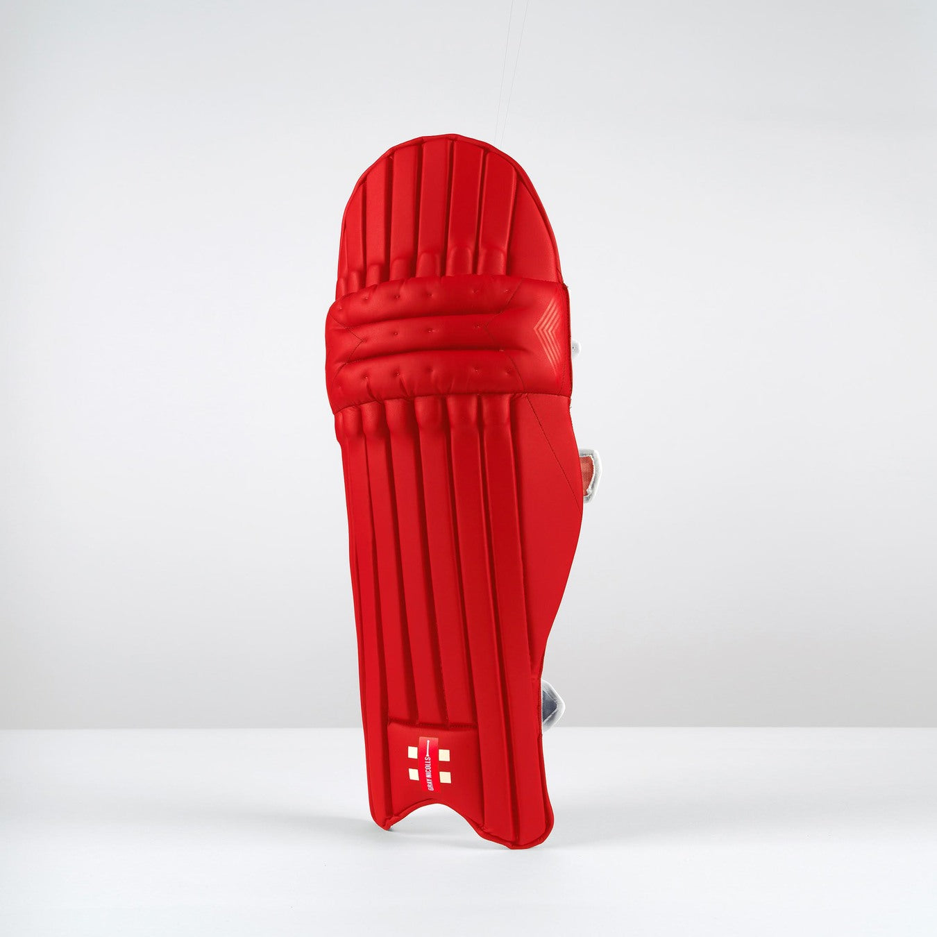 A single Gray Nicolls Classic Select Batting Pad 2026 in red stands upright on a white surface with a plain white background, featuring the Gray Nicolls logo near the bottom.