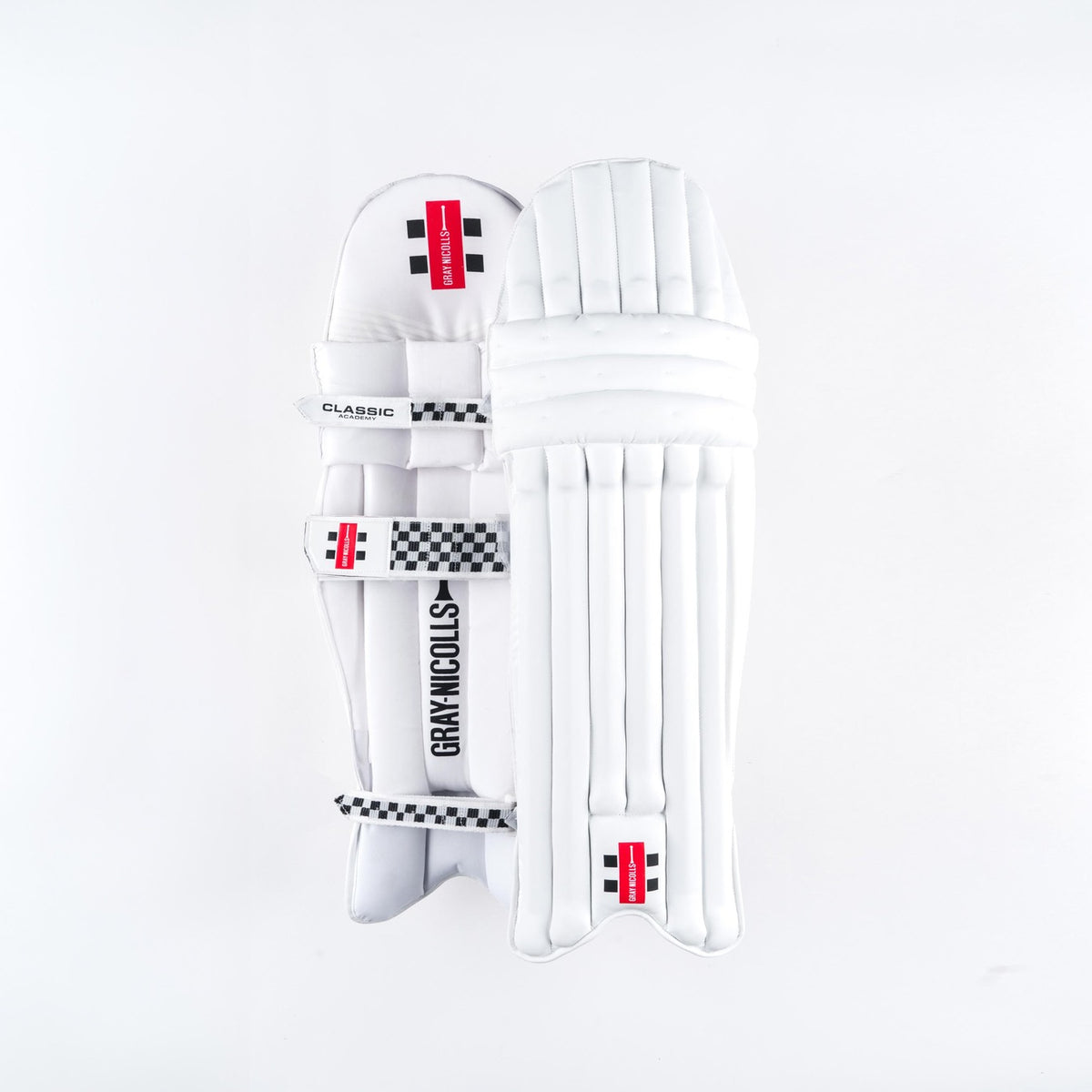 Gray Nicolls Classic Academy Batting Pads 2026: Junior pads with a lightweight PU front, black checkered details, secure straps, and red branding labels by Gray Nicolls, shown on a plain white background.