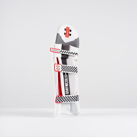 The Gray Nicolls Imperia 1.0 Batting Pad 2026, featuring black and red accents with checkered straps and the Gray Nicolls logo, stands upright on a white background, delivering premium cricket protection and high-impact resistance.
