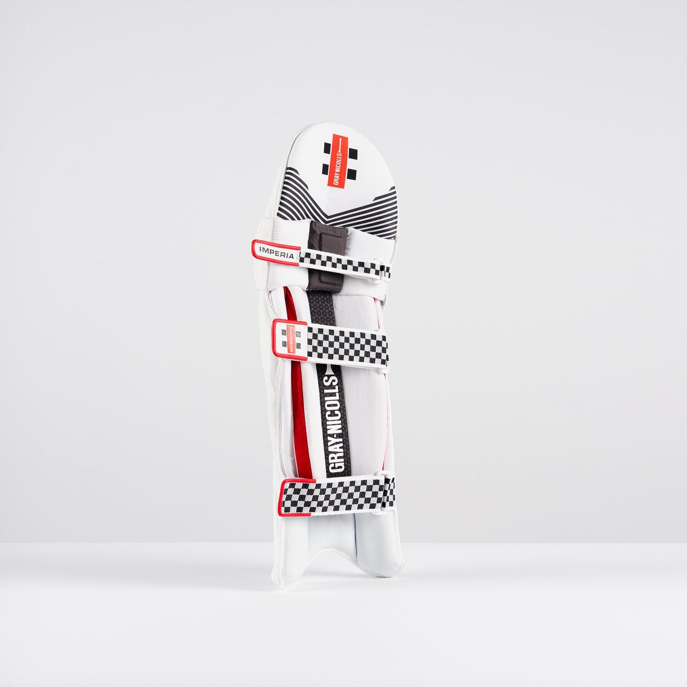 The Gray Nicolls Imperia 1.0 Batting Pad 2026, featuring black and red accents with checkered straps and the Gray Nicolls logo, stands upright on a white background, delivering premium cricket protection and high-impact resistance.