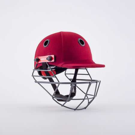 The Gray Nicolls Elite Junior Helmet in maroon features black air vents, an adjustable chin strap, and a metal face guard, shown against a plain white background.