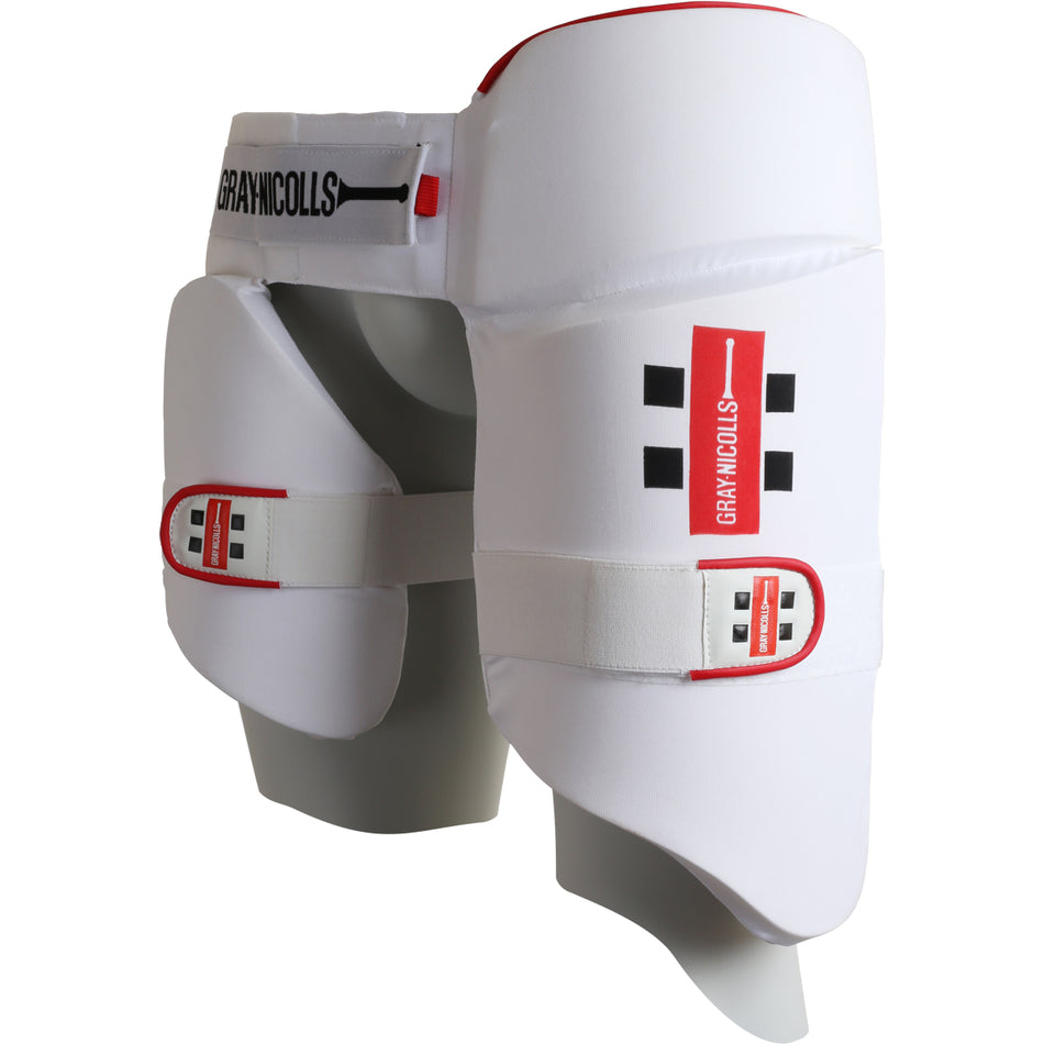 The Gray Nicolls All in One 360 Thigh Pad is a white thigh pad with black and red Gray Nicolls branding, adjustable straps, extra padding for protection, and a curved design that comfortably fits around the thighs and hips.