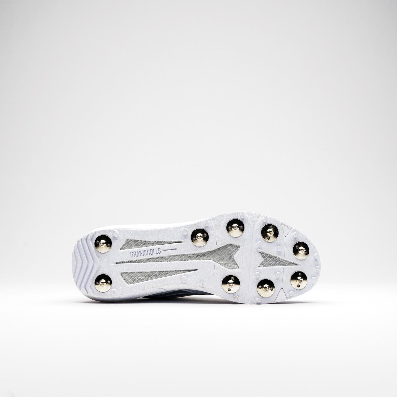 The Gray Nicolls Revo Pro 2.0 Cricket Spikes is a white shoe with six metal spikes, grey mesh accents, and visible Gray Nicolls branding on the sole. It features Energise midsole technology for enhanced performance.