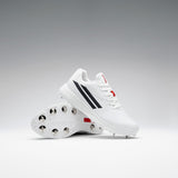 A pair of Gray Nicolls Revo Pro 3 Cricket Spikes is displayed against a gradient background, one upright and one leaning to highlight the metal spikes, featuring lightweight design with black stripes and red accents.