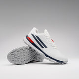 The Gray Nicolls Revo Pro 3 Cricket Batting Shoe features a white upper with dark blue stripes, red accents, and textured gray soles. One shoe stands upright while the other lies on its side to display the tread pattern.