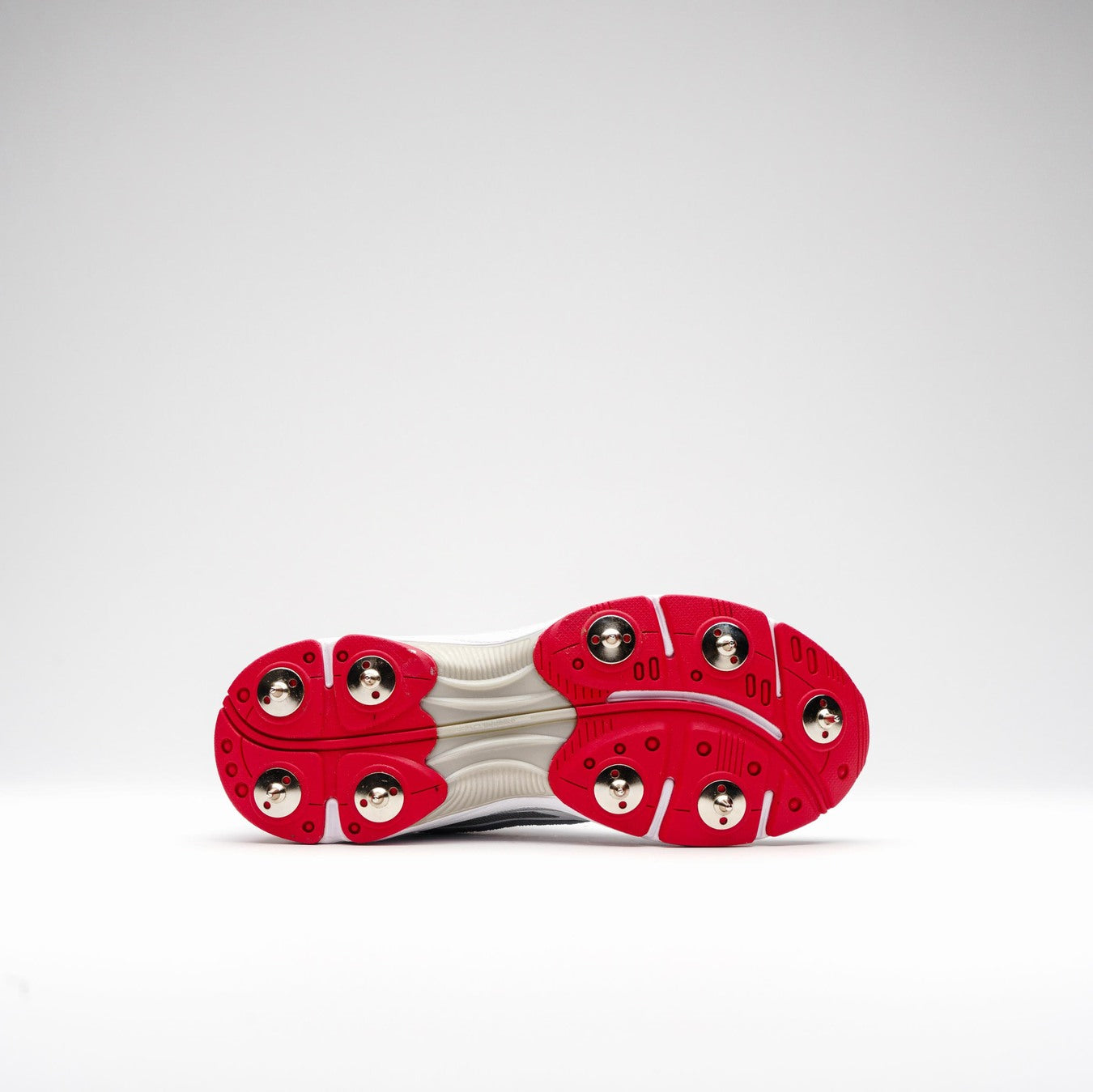 The image shows the underside of the Gray Nicolls Velocity 5.0 Cricket Spikes by Gray Nicolls, featuring a white EVA performance midsole and red accents with six rounded, metallic silver pods on a plain white background.