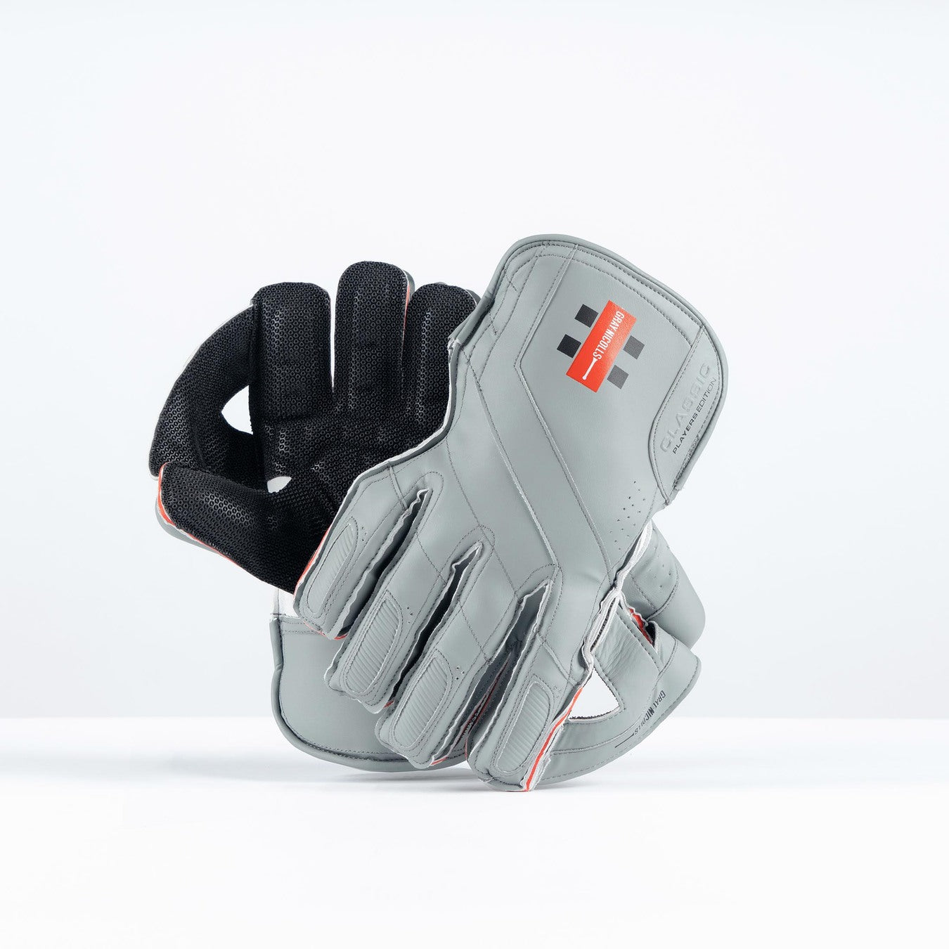 The Gray Nicolls Classic Pro Performance WK Gloves 2026, in grey with black mesh lining and red detailing, are displayed upright on a white background. These modern gloves feature Octopus grip and a small red and black Gray Nicolls wrist logo.